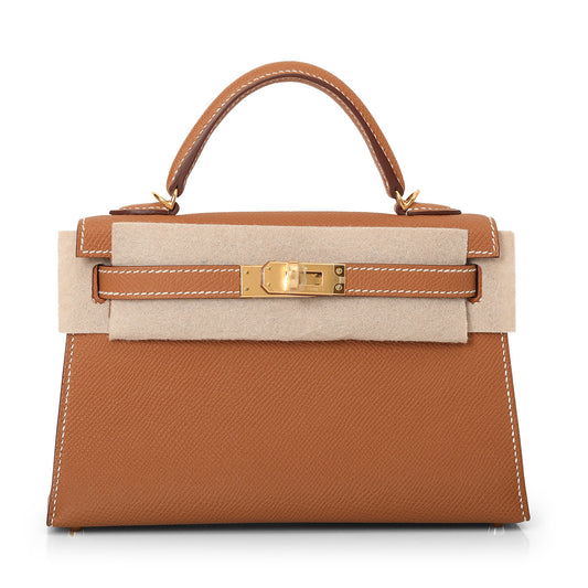 A brown Hermes Kelly 22 handbag with a gold hardware clasp and a beige canvas strap.