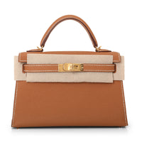 A brown Hermes Kelly 22 handbag with a gold hardware clasp and a beige canvas strap.